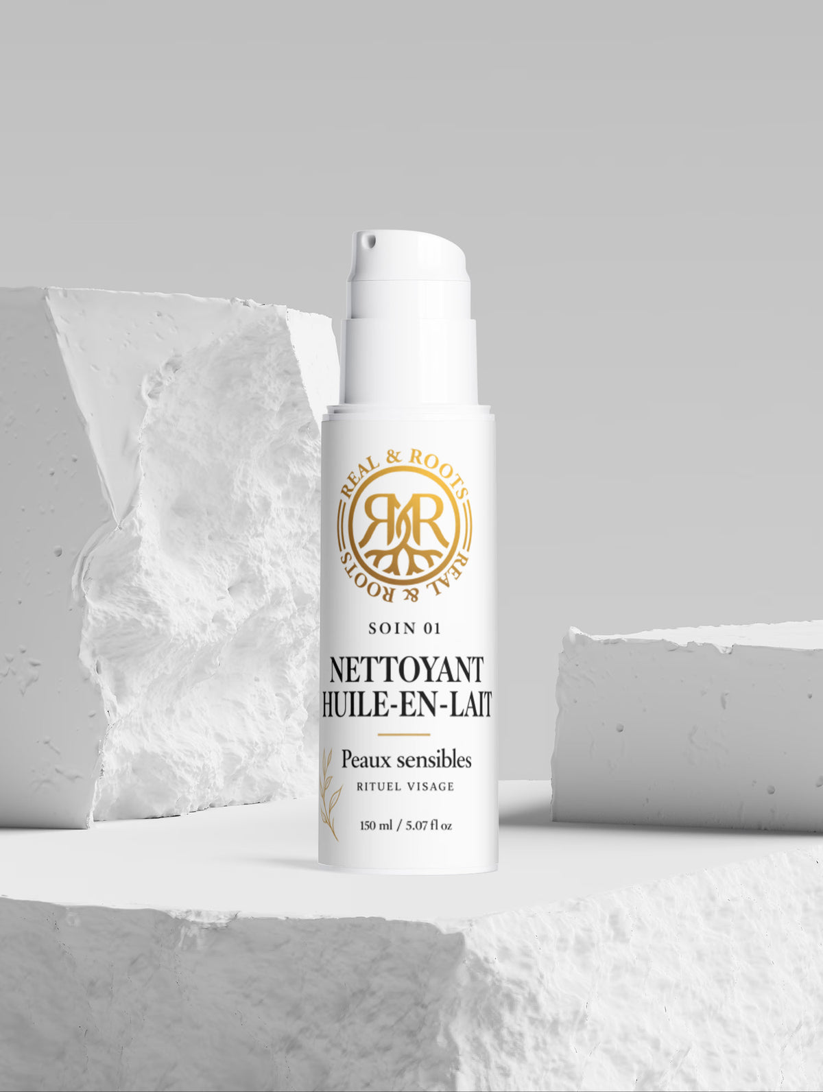 Nettoyant huile-en-lait Real & Roots sur un décor de pierre blanche